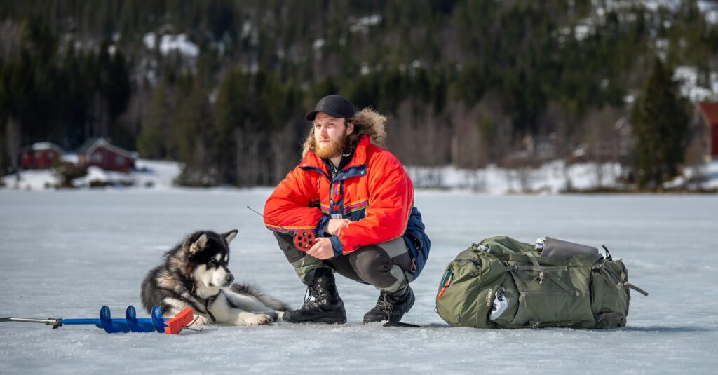 A man and his husky enjoy a winter ice fishing trip on a frozen lake.